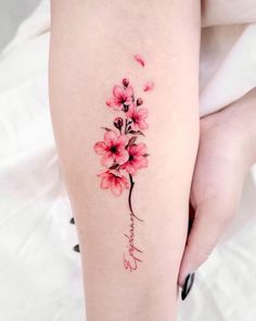 a woman's leg with pink flowers on it and the word love written in cursive writing