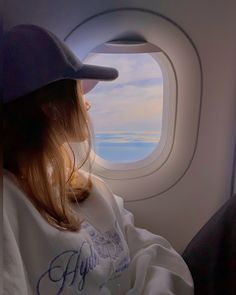 a woman sitting on an airplane looking out the window