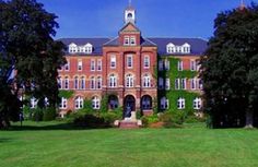 an old brick building with many windows and trees