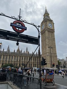 the big ben clock tower towering over the city of london with people walking around it