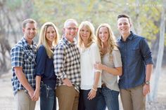 a group of people standing next to each other in front of trees and dirt ground