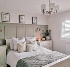 a bedroom with a bed, nightstands and pictures on the wall