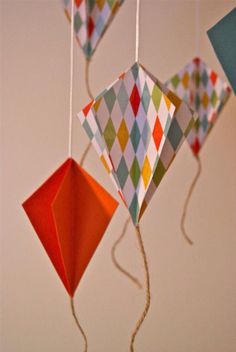 several colorful kites hanging from strings in a room