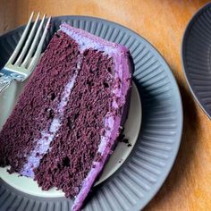 a slice of purple cake on a plate with a fork