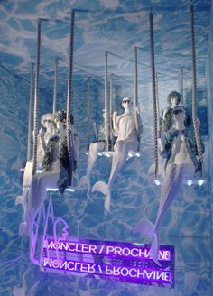 there are many mannequins hanging in the water with lights on them and signs below