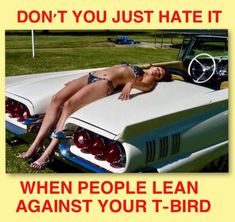 a woman laying on the hood of a car with an advertisement in front of her