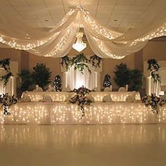 a banquet hall decorated with lights and greenery