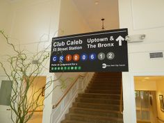 a sign hanging from the side of a stair case next to a potted plant