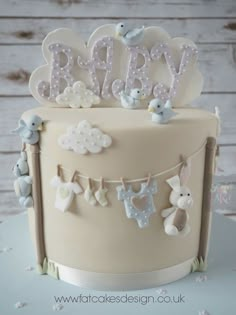 a baby cake decorated with teddy bears and bunting on the top is white frosting