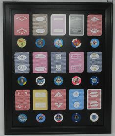 a black frame with several different colored stickers on it and a white wall in the background