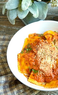 a white bowl filled with pasta and sauce