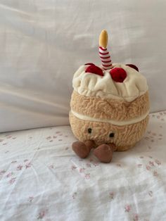 a stuffed animal with a birthday hat on it's head sitting on a bed