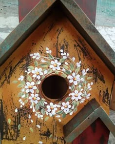 a birdhouse with painted flowers on it