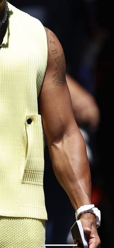 a close up of a tennis player's arm and shoulder with tattoos on it