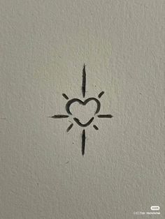 a heart drawn on the side of a wall with an arrow and sun in it