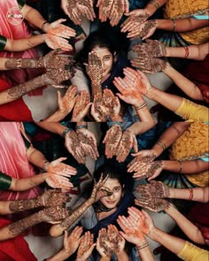 many people are holding their hands together in the shape of a circle with painted hands