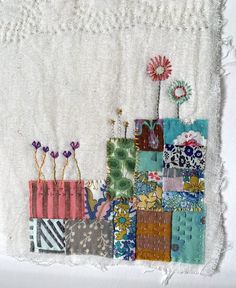 a piece of fabric with different colored patches and flowers on it that is stitched together