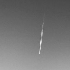 an airplane is flying in the sky leaving a trail