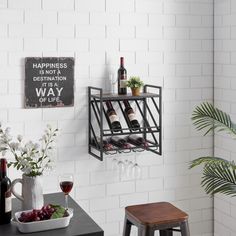 a wall mounted wine rack with bottles and glasses on it next to two stools