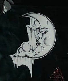 a drawing of a crescent moon with clouds hanging from it's side in the dark