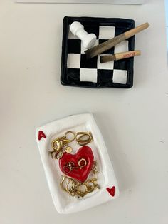 two pieces of art on a table with scissors and other items in the trays