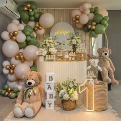 a baby shower with teddy bears and balloons on the wall, greenery and decorations