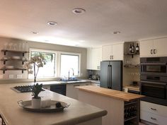 a kitchen with an island, stove, sink and refrigerator freezer combo in it