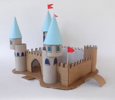 a castle made out of cardboard sitting on top of a white table next to a red flag