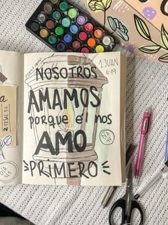 an open notebook with spanish words on it next to markers, pens and other art supplies