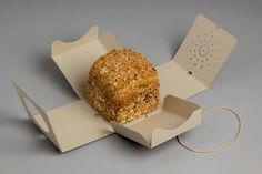 a piece of bread in a box on top of a gray surface with a string attached to it