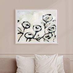 a painting hanging on the wall above a bed with pillows and pillow cases in front of it