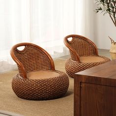 two wicker chairs sitting next to each other on top of a rug in front of a window