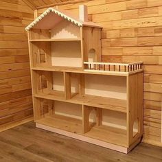 a doll house built into the side of a wooden shelf in a room with wood paneling