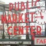 a public market center sign with a clock on it