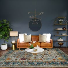 a living room with blue walls and wood flooring is furnished with an orange leather couch