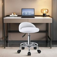 a desk with a laptop on it and a white chair in front of the desk