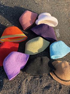 six hats laying on the ground with one hat in the middle, and two are different colors