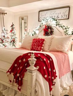 a bedroom decorated for christmas with red and white decor