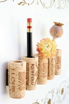 there are four wine corks on the wall and one is holding a lipstick bottle