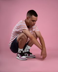 a young man sitting on the ground with his foot up in front of his face