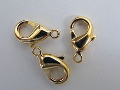 three gold plated metal clasps on a white background with the caption reads, bead - fast findings depot