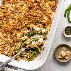 a casserole dish filled with green beans, cheese and other toppings on a table