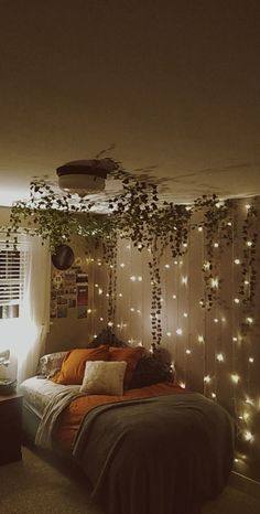 A room with vines hanging from the ceiling Vines Led Lights Bedroom, Hanging Veins Bedroom, Curtain Lights Bedroom Wall Vine, Leafs On Ceiling Aesthetic, Hanging Ivy Bedroom Wall, Dorm Fairy Lights Room Ideas, Vines Hanging Above Bed, Ascetic Bedroom Ideas, Room Decor Ivy Vines