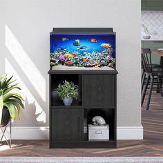 a fish tank sitting on top of a wooden shelf next to a potted plant