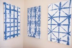 three blue and white paintings hanging on the wall