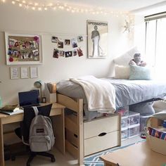 a dorm room with a bed, desk and computer