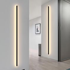 a white room with some lights on the wall and a door in the corner next to it