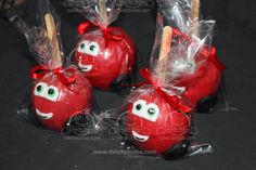 four red apples wrapped in cellophane and decorated with googly eyes, bows and toothpicks