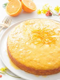 a cake on a plate with oranges next to it