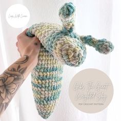 a hand holding a crocheted stuffed animal in front of a white background with the words cross the great without shy written below it